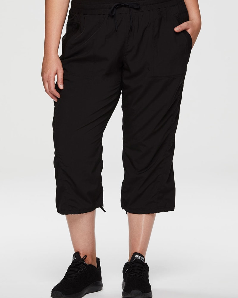 Front of a model wearing a size 1X Lumen Lightweight Capri Pant in Black by RBX Active. | dia_product_style_image_id:244595